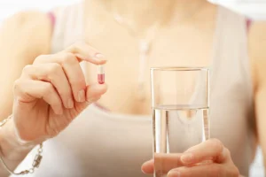 A woman taking a supplement to help with menopause symptoms